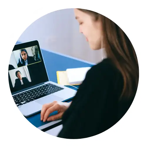 A woman is sat at a desk using online translation services on her laptop.